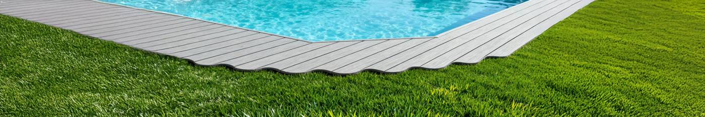 composite decking and artifical grass by poolside in garden