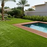 seneca artificial grass turf in villa back garden with pool and palm tree