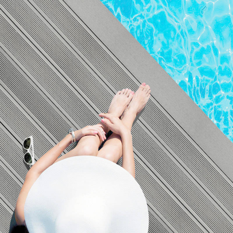 woman sitting by pool on grey smart decking