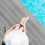 woman sitting by pool on grey smart decking