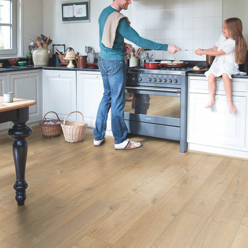 man and girl in kitchen space with quick step soft oak medium laminate flooring