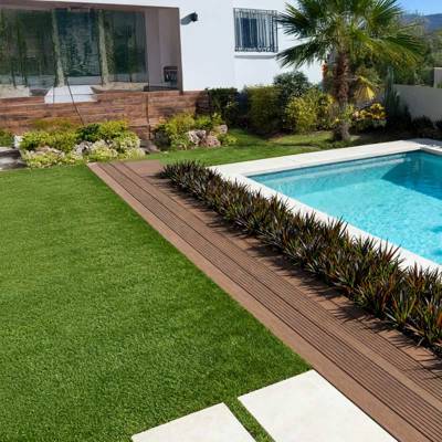 redwood 30 artificial grass in villa back garden next to pool and shrubs